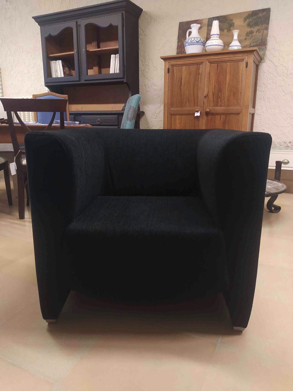 Black rectangular armchair, with armrests.
